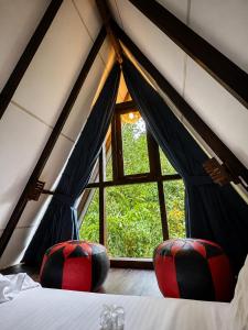 two red and black chairs in a room with a window at THE JUNGLE CABIN ella in Ella