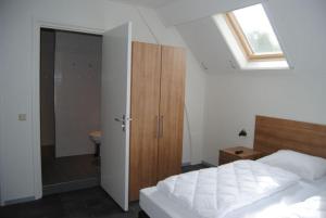 a bedroom with a bed and a bathroom with a window at Duinoord Oostkapelle in Oostkapelle