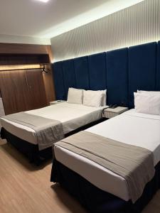 two beds in a room with blue walls at Américas Benidorm Hotel in Rio de Janeiro