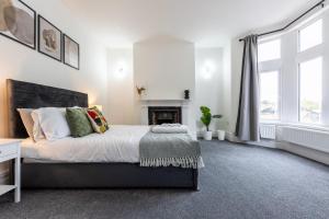 a bedroom with a large bed and a fireplace at Spacious 6BR Cardiff House w/ Free Parking in Cardiff +17 photos
