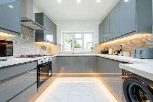 a large kitchen with a washer and dryer at Spacious 6BR Cardiff House w/ Free Parking in Cardiff