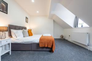 a bedroom with a bed with an orange blanket on it at Spacious 6BR Cardiff House w/ Free Parking in Cardiff