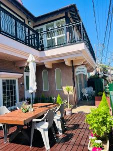 a house with a wooden table and chairs on a patio at Pension Green Grass in Kamakura