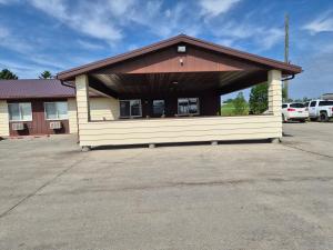 a small building with a brown roof on a parking lot at Drayton Inn in Drayton