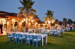 a group of tables and chairs in front of a building at Regnum Carya in Belek
