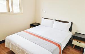 a bedroom with a large white bed with two windows at Ferry Bow in Jincheng +2 photos