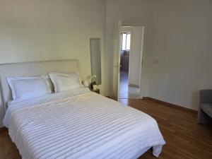 a bedroom with a large white bed with white sheets at La parenthèse du lac in Bevaix