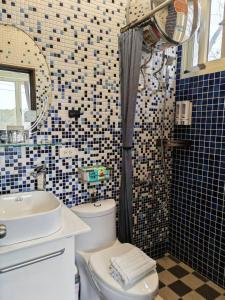 a bathroom with a toilet and a sink and a shower at Ferry Bow in Jincheng