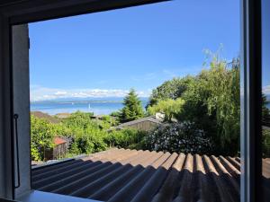 a view of the ocean from a window at La parenthèse du lac in Bevaix +2 photos