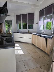 a kitchen with white cabinets and black counter tops at La parenthèse du lac in Bevaix