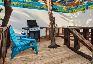a patio with a blue chair and a stove at Blue Sail Apartments in Simpson Bay