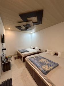 a bedroom with two beds and a ceiling at The MEERA in Godarpura