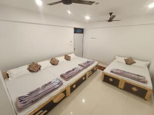 a bedroom with two beds and a ceiling fan at The MEERA in Godarpura