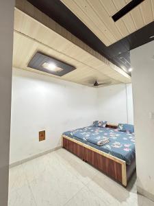 a bedroom with a bed in a white wall at The MEERA in Godarpura