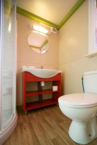 baño con lavabo rojo y aseo en Camping Piper, en Puntone di Scarlino