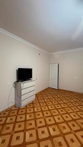 an empty living room with a television and a wooden floor at Joni Mot in Goris