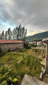 an old building in a field with trees in the background at Joni Mot in Goris