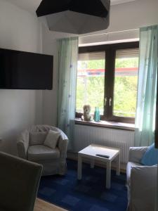 a living room with a couch and a chair and a window at Apartmenthaus Kornstrasse in Bremen