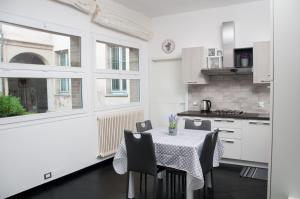 a kitchen with a table and chairs and a kitchen with white cabinets at 29 by Le Suite in Lugo