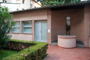 a brick house with a blue door and bushes at 29 by Le Suite in Lugo