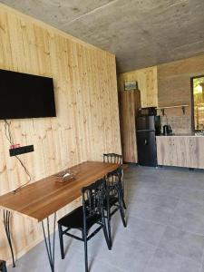 a dining room with a wooden table and chairs at Jvarisa cottages in Bugeuli