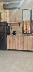 a kitchen with wooden cabinets and a black refrigerator at Jvarisa cottages in Bugeuli