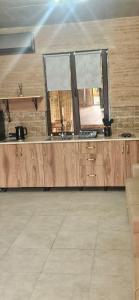 a large kitchen with wooden cabinets and windows at Jvarisa cottages in Bugeuli +18 photos