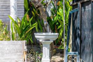 a white sink in a garden with a fountain at The Box Paradise Bungalow in Nusa Penida