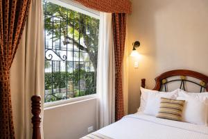 a bedroom with a bed and a window at Casa Aliso Hotel Boutique in Quito