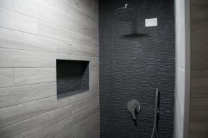 a bathroom with a shower with a phone on the wall at 29 by Le Suite in Lugo +50 photos