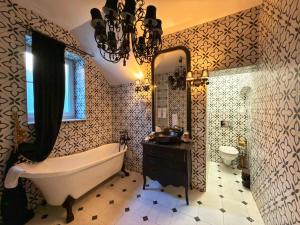 a bathroom with a tub and a sink and a mirror at Conacul Coroanei Luxury Boutique in Bucharest