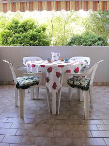 a table and chairs with a table and a tea pot on it at Appartamenti Nasse in Bibione