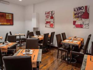 a dining room with tables and chairs and paintings on the wall at Hotel Infinity San Pietro in Rome +11 photos