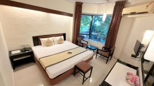 a bedroom with a large bed and a window at Hotel Garden Panvel - Near Navi Mumbai Airport in Navi Mumbai +31 photos