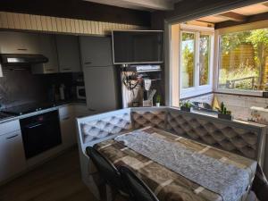 a kitchen with a table with chairs and a window at Refuge de l'Ecureuil in Métabief +21 photos