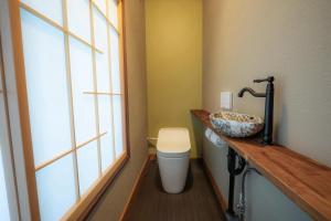 a bathroom with a toilet and a sink and a window at 福渡邸 in Narita