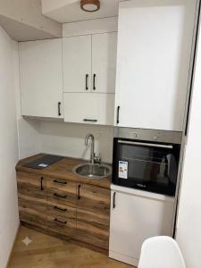 a small kitchen with a sink and a microwave at Božur 2 in Vrnjci