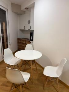 a white table and four white chairs in a kitchen at Božur 2 in Vrnjci