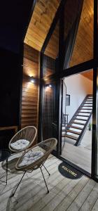 two chairs on a wooden deck with a staircase at Sky Chalet in Ndërlysaj
