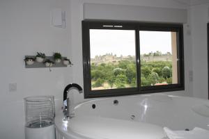 uma casa de banho com uma banheira e uma janela em Les Suites du Saint Nazaire - Les Balcons de la Cité em Carcassonne