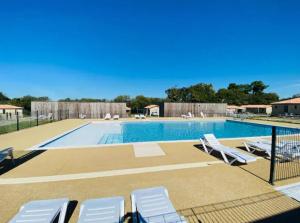 a swimming pool with lounge chairs and a swimming pool at Le Clos de Mizou "Dog Friendly" comme à la maison in Saubrigues