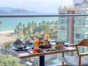 a table with plates of food on a balcony at Ocean Win Panorama Nha Trang in Nha Trang