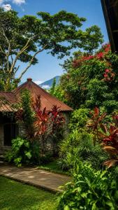 a house with a garden with trees and flowers at Furahia Eco Inn in Usa River