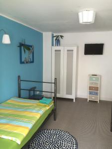 a bedroom with a bed and a blue wall at Apartmenthaus Kornstrasse in Bremen