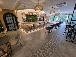 a restaurant with a bar with tables and chairs at First Flatotel International in Benalmádena