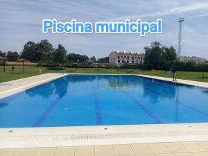 a large swimming pool with blue water in a park at El Corral de la Higuera in Campofrío