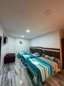 a large bedroom with two beds and a couch at Hotel Imperial in Santo Domingo de los Colorados +4 photos
