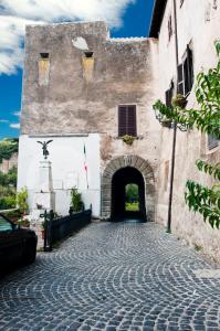 un vieux bâtiment avec une arche dans une rue dans l'établissement Casa Graziella al Borgo, à Mazzano Romano
