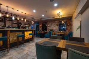 a restaurant with a bar and tables and chairs at Luna Hotel Astana in Astana