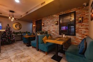 a restaurant with a christmas tree and blue chairs at Luna Hotel Astana in Astana